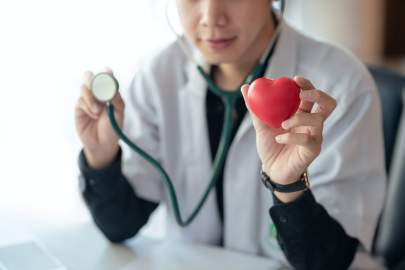 male-doctor-holding-red-heart-and-stethoscope-in-t-2023-11-27-04-46-39-utc